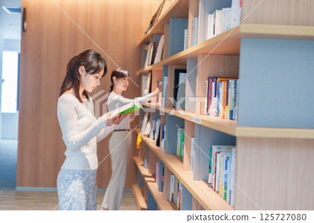 Young woman searching for a book in a library Young woman searching for a book in a library 125727080
