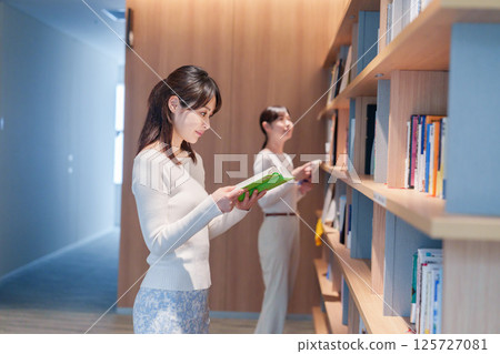 Young woman searching for a book in a library 125727081