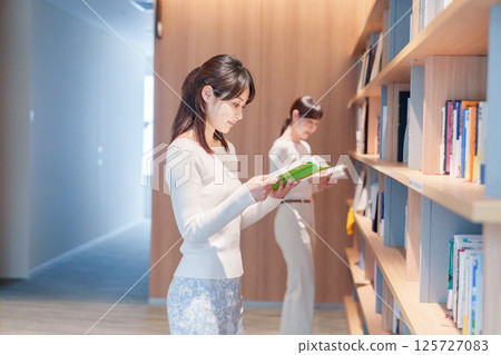 Young woman searching for a book in a library Young woman searching for a book in a library 125727083