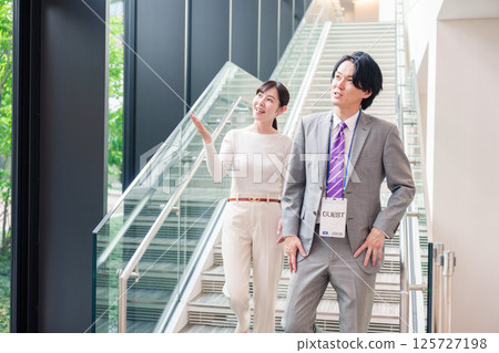 A female business person guiding guests 125727198