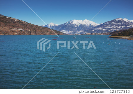 View of Serre-Poncon mountain lake in winter from the Savines Bridge. Hautes Alpes, France 125727513