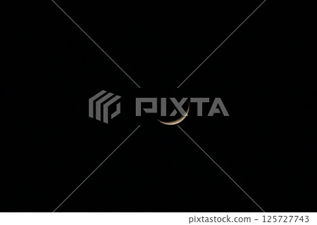 Crescent moon floating in the night sky 125727743