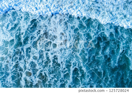Ocean surf. Waves roll onto the shore. View from above. Natural abstract background Ocean surf. Waves roll onto the shore. View from above. Natural abstract background 125728024