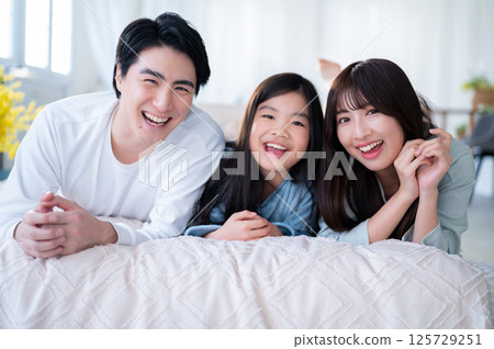 A happy moment with the three family members huddled together and smiling peacefully A happy moment with the three family members huddled together and smiling peacefully 125729251