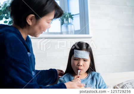 The warm gaze of a mother nursing her sick child The warm gaze of a mother nursing her sick child 125729256