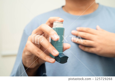 Asthma and chronic obstructive pulmonary disease COPD, Asian young man using metered dose inhaler MDI. Asthma and chronic obstructive pulmonary disease COPD, Asian young man using metered dose inhaler MDI. 125729268