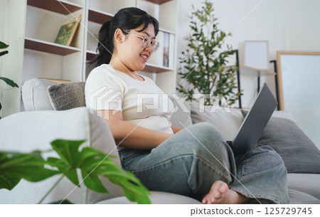 Asian young woman working on laptop computer, sending email, studying online, social networking Asian young woman working on laptop computer, sending email, studying online, social networking 125729745