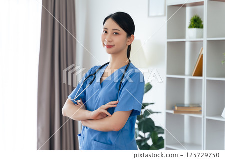 Asian female doctor or nurse standing confidently with stethoscope hanging on her neck 125729750