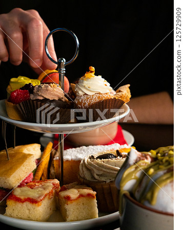 Selecting Pastries from a Tiered Stand Selecting Pastries from a Tiered Stand 125729909