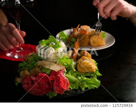 Culinary Encounter: Savoring Red Wine with a Diverse Selection of Appetizers 125729916