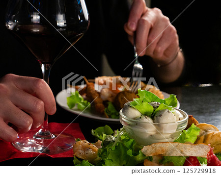 A Culinary Moment: Red Wine Accompanies a Delectable Plate of Mixed Appetizers A Culinary Moment: Red Wine Accompanies a Delectable Plate of Mixed Appetizers 125729918