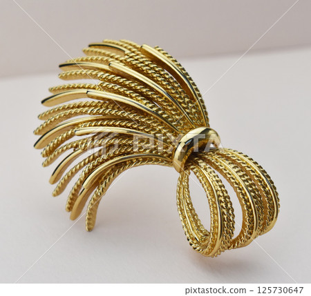 Elegant handmade brooch accessory for women laid out on textured surface for promo Elegant handmade brooch accessory for women laid out on textured surface for promo 125730647