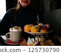 Smiling Woman Enjoying High coffee 125730790