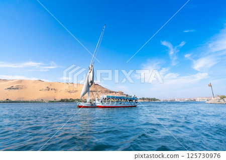 Tourist Felucca Sailing on Nile near Aswan, Egypt. Tourist Felucca Sailing on Nile near Aswan, Egypt. 125730976