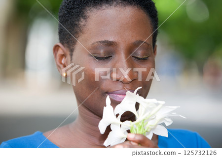 close up of young woman with a flower. 125732126