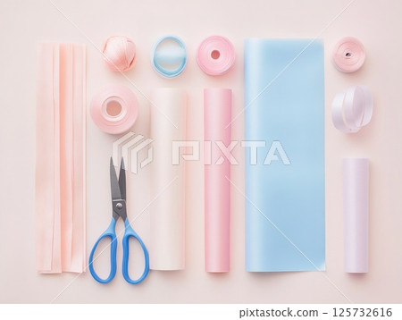 Creative holiday gift wrapping supplies flat lay featuring scissors, ribbons, and pastel papers 125732616