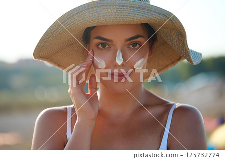 Woman smile applying sun cream on face. Skincare. Body Sun protection. sunscreen. Female smear moisturizing lotion on skin 125732774