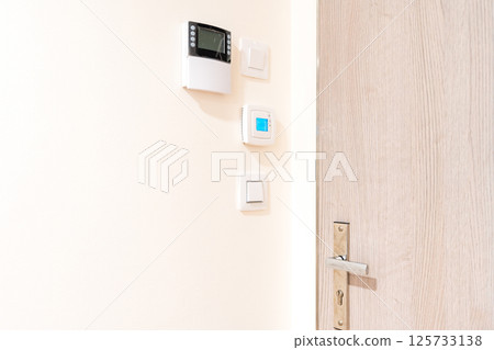 Smart home control panel and thermostat on white wall in modern interior Smart home control panel and thermostat on white wall in modern interior 125733138