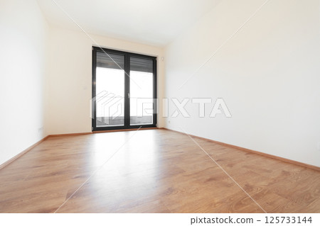 Spacious, bright room in a contemporary apartment with wooden floor and a tilt and turn window  125733144