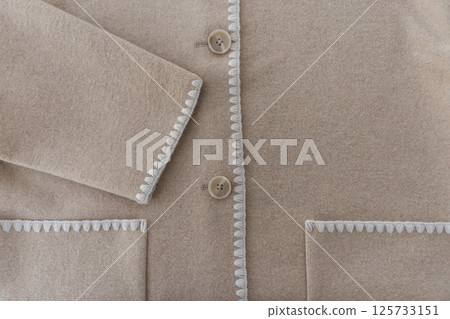 Wool blend coat with decorative stitching and sleeve detail close-up with copy space 125733151