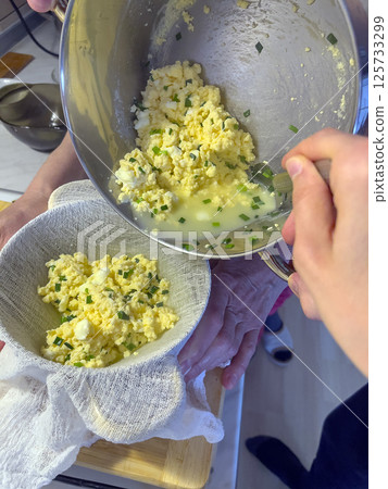 The process of making homemade cheese with green onion feathers. 125733299