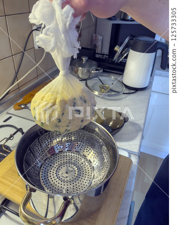 Women's hands prepare homemade cheese. 125733305