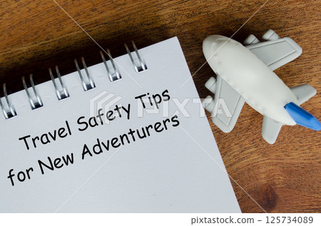 Travel Safety Tips for New Adventures text on white notepad with toy airplane 125734089