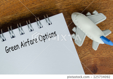 Green Airfare Options text on white notepad with toy airplane. 125734092