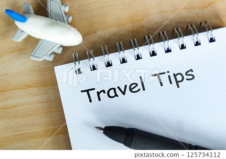 Top view of Travel Tips text on white notepad. Getaway concept. 125734112