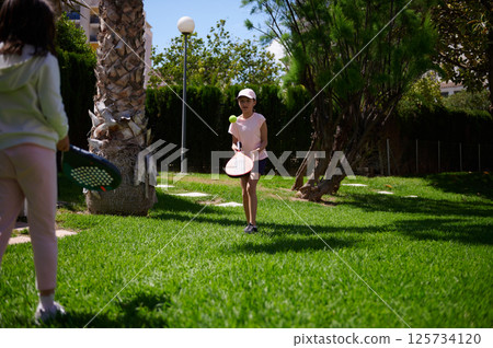 Children Enjoying a Friendly Game of Paddle Tennis in the Park 125734120