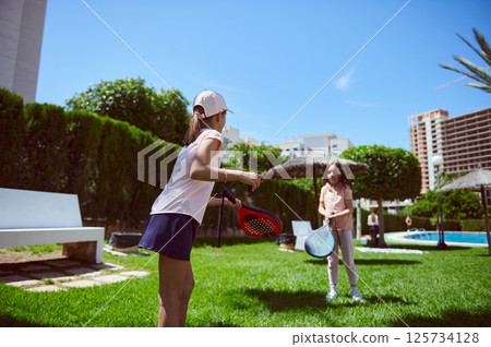 Outdoor Weekend Fun with Kids Playing Paddle Tennis in Park Outdoor Weekend Fun with Kids Playing Paddle Tennis in Park 125734128