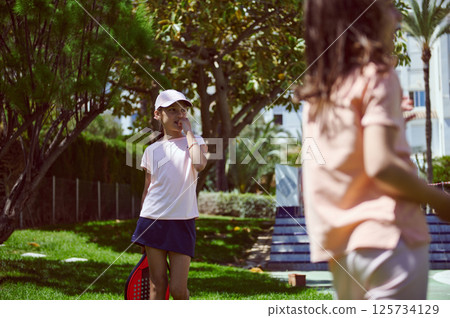 Two Girls Playing Paddle Tennis in a Park on a Sunny Day Two Girls Playing Paddle Tennis in a Park on a Sunny Day 125734129