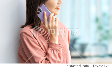 微笑的女人/女商人在智慧型手機上交談 125734178