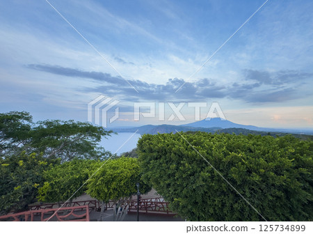 Majestic landscape view of serene lake with mountains in background at sunset 125734899