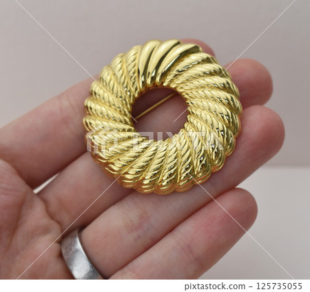 Vintage brooch floral detail laid on soft fabric Vintage brooch floral detail laid on soft fabric 125735055