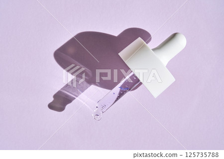 Pipette with serum on purple background with sunlight. 125735788
