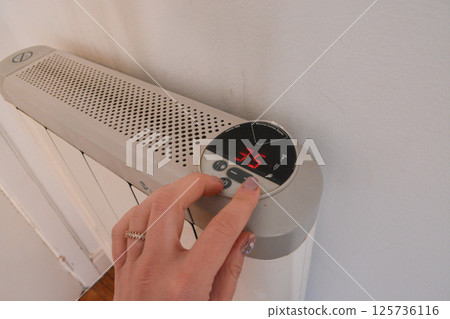 white modern heating knob on high battery mode for heating in apartments and houses. Heating prices. Concept of electricity price increase, electricity saving, reasonable consumption white modern heating knob on high battery mode for heating in apartments and houses. Heating prices. Concept of electricity price increase, electricity saving, reasonable consumption 125736116