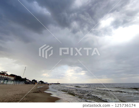 Rain and storm at sea. Dark storm clouds, rain and sea surface. Stormy weather. Storm at sea. Nature. Natural background. 125736174