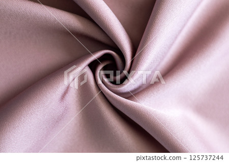 Close-up of soft pink silk fabric with elegant folds and swirls Close-up of soft pink silk fabric with elegant folds and swirls 125737244