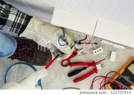 Electrician at work on a residential electrical system. Electricity.  125737433