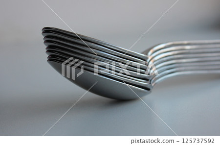 Stuck Of Same Size Silvery Spoons On Clean White Surface. Concept Photo For Table Setting Illustration 125737592
