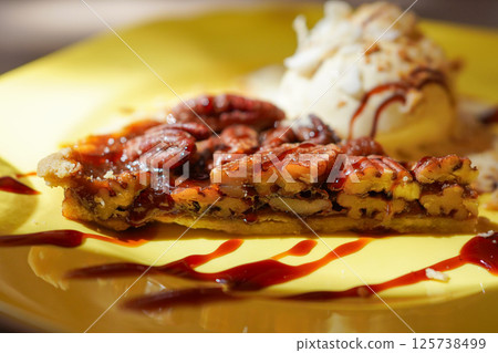 Homemade pecan pie with caramel sauce and vanilla ice cream 125738499