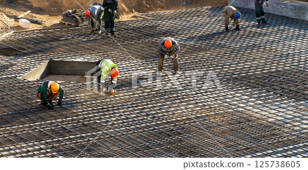 Brigade of builders knit fittings for pouring concrete. Brigade of builders knit fittings for pouring concrete. 125738605