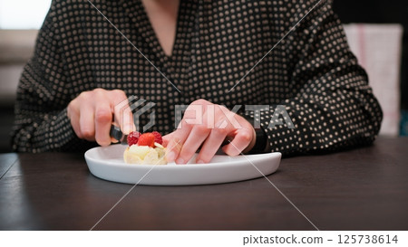 Woman Shares Fruit Pastry Food Sitting At Table In The Morning Woman Shares Fruit Pastry Food Sitting At Table In The Morning 125738614