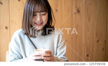 Smiling Japanese woman at a wooden cafe 125739336