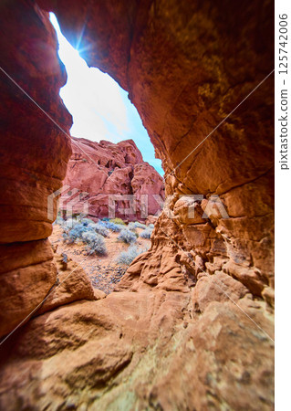 Desert Sandstone Formations Through Natural Arch Midday Sunburst Perspective Desert Sandstone Formations Through Natural Arch Midday Sunburst Perspective 125742006