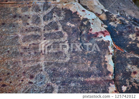 Ancient Petroglyphs on Weathered Rock Surface Close-Up 125742012