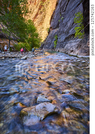 Hikers Exploring Zion Narrows at Golden Hour Eye Level Perspective 125742163