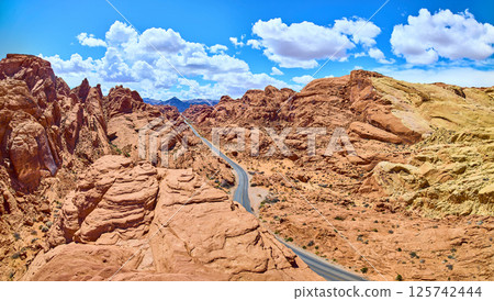 Desert Red Rock Panorama with Winding Road and Blue Sky Desert Red Rock Panorama with Winding Road and Blue Sky 125742444