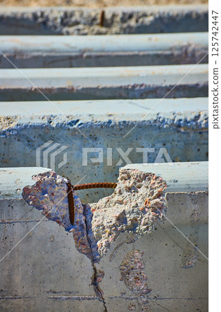Exposed Rebar and Cracked Concrete Close-Up at Eye Level Exposed Rebar and Cracked Concrete Close-Up at Eye Level 125742447